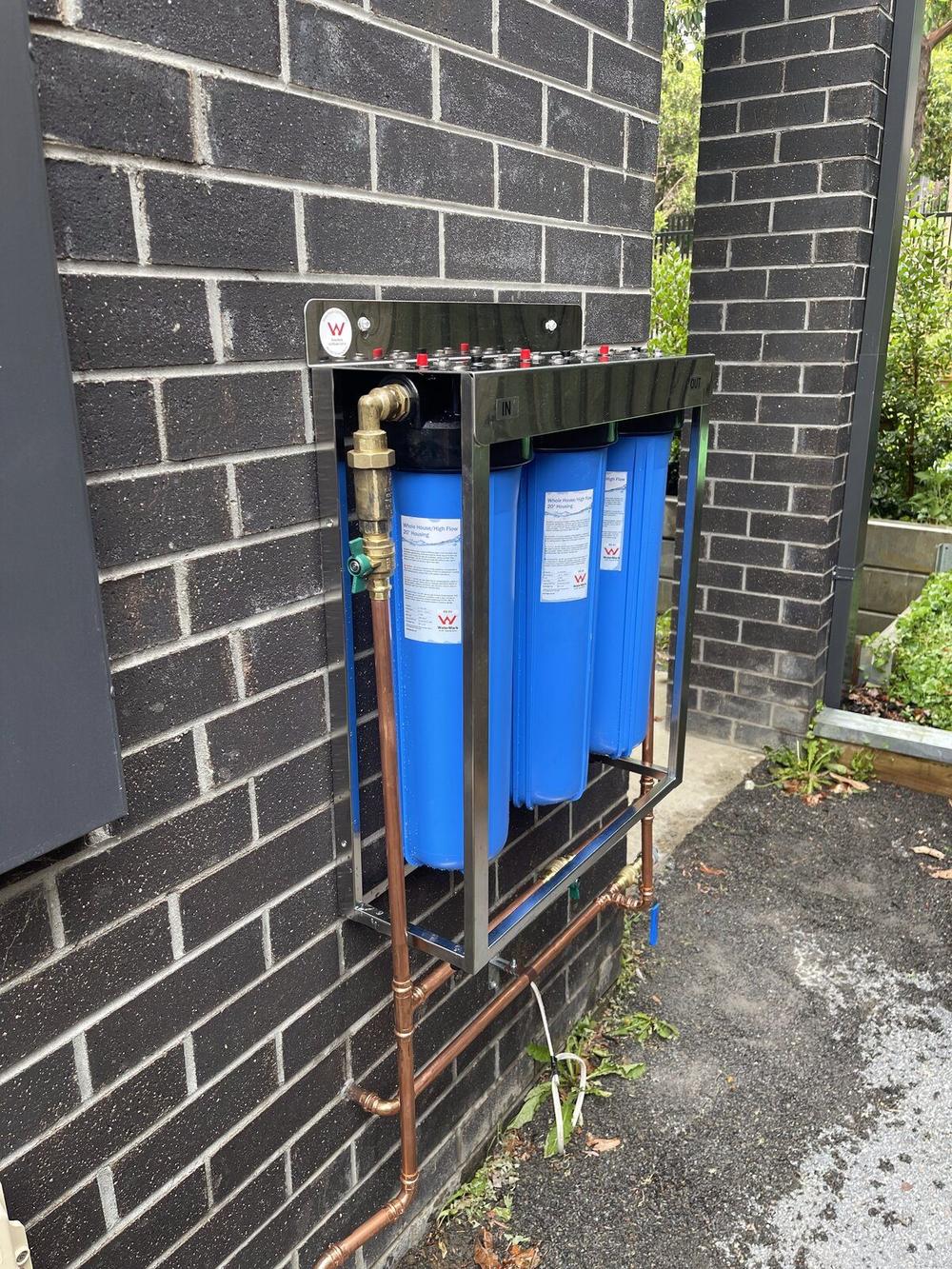 Dual stage water filter mounted on exterior brick wall Hawthorn
